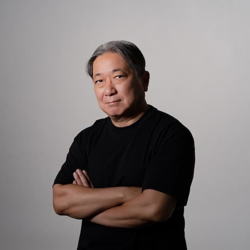 第10研究室　教授　藤崎圭一郎 プロフィール写真1 / 正面を向いた顔、体は斜めを向き腕を組んでいる。
