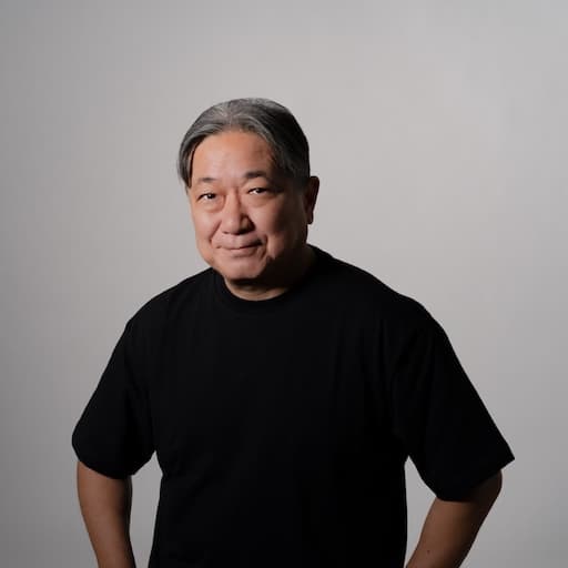 第10研究室　教授　藤崎圭一郎 プロフィール写真2 / 腰に手を当てて、正面を向き微笑んでいる。